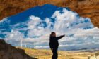 Engineer inside a cave points at wind turbines, a clean energy source to be discussed at the Scottish Energy Futures Conference