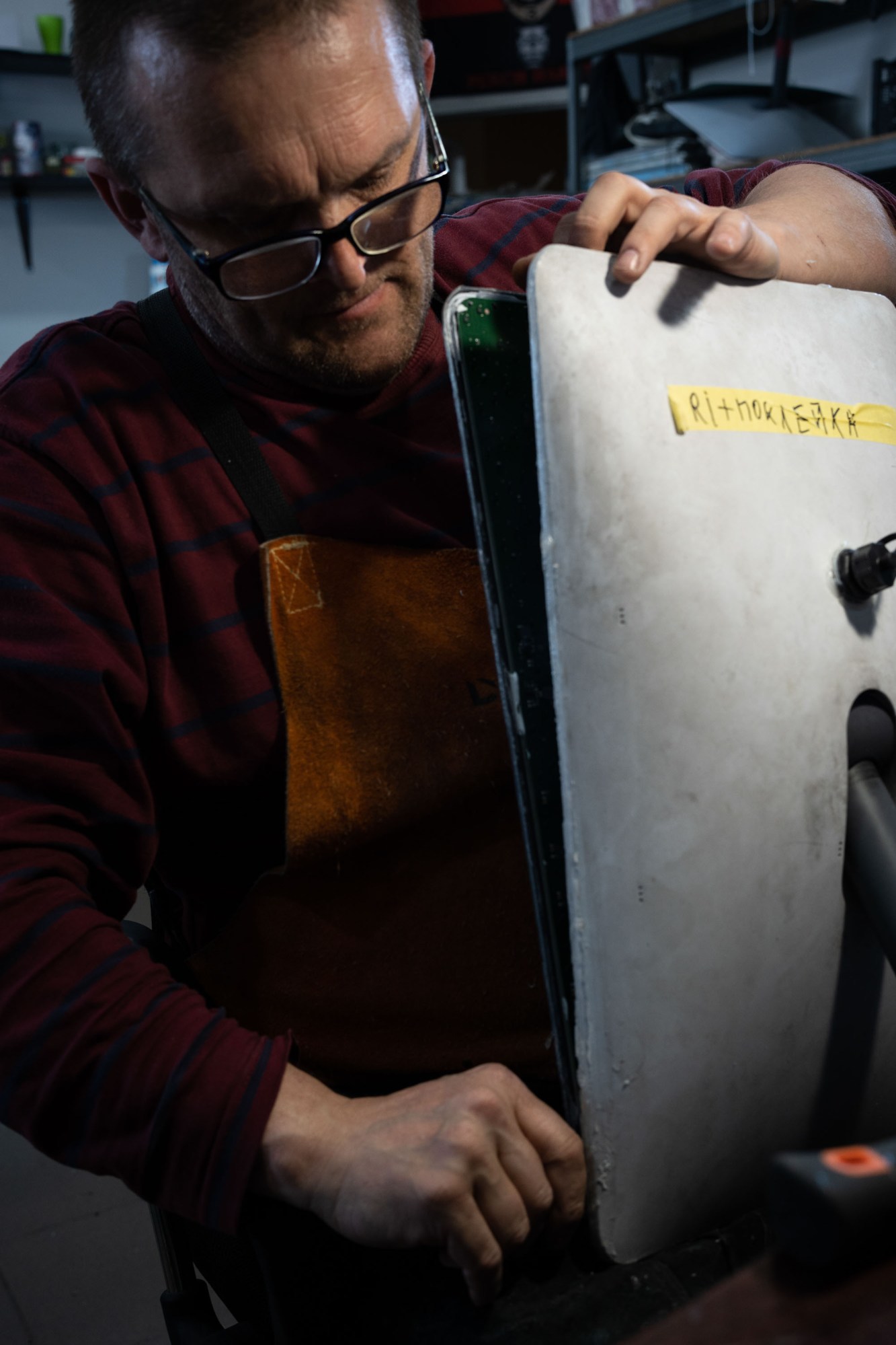 a volunteer holding a Starlink vertically to pry it open