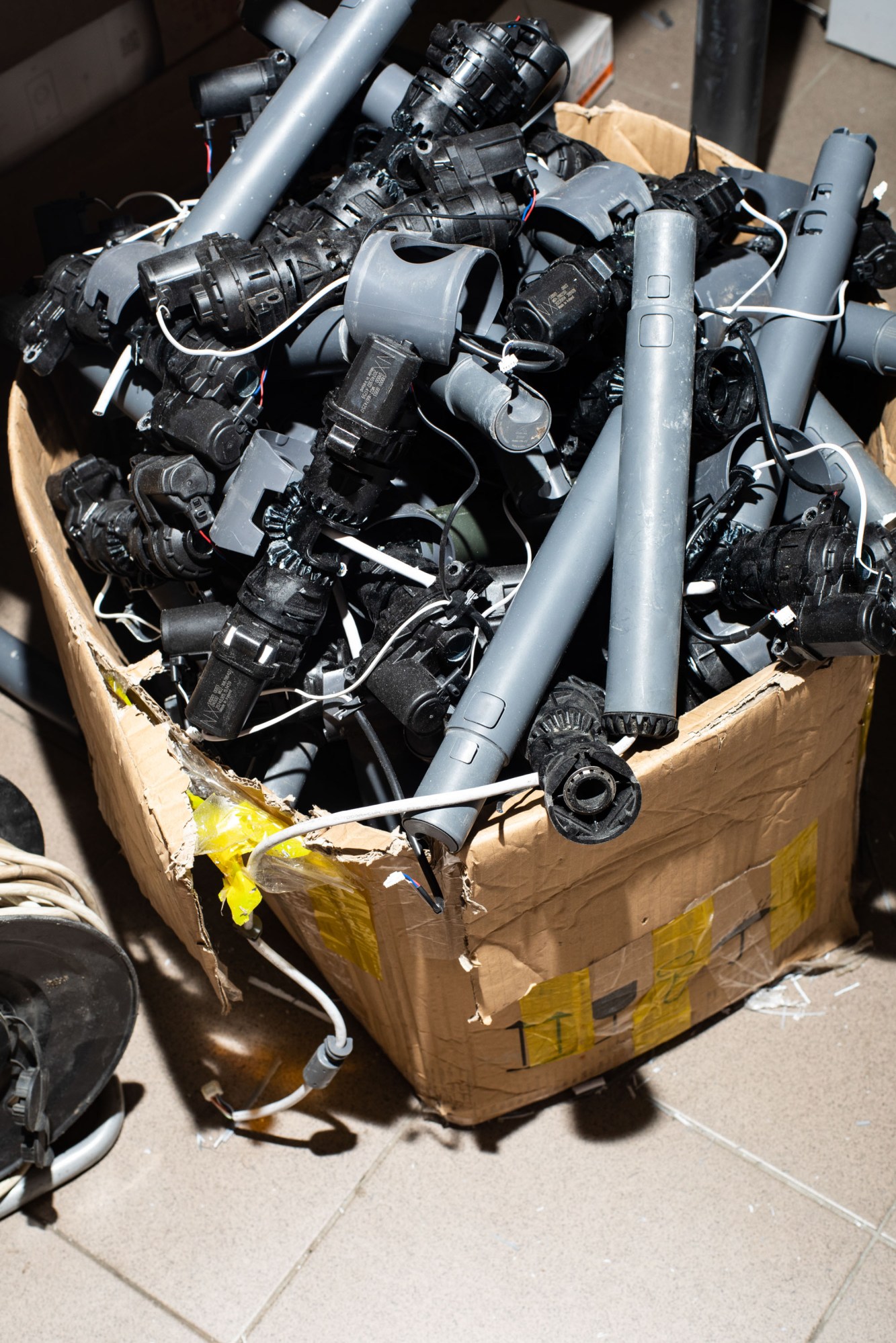 a carboard box stuffed with grey cylinders