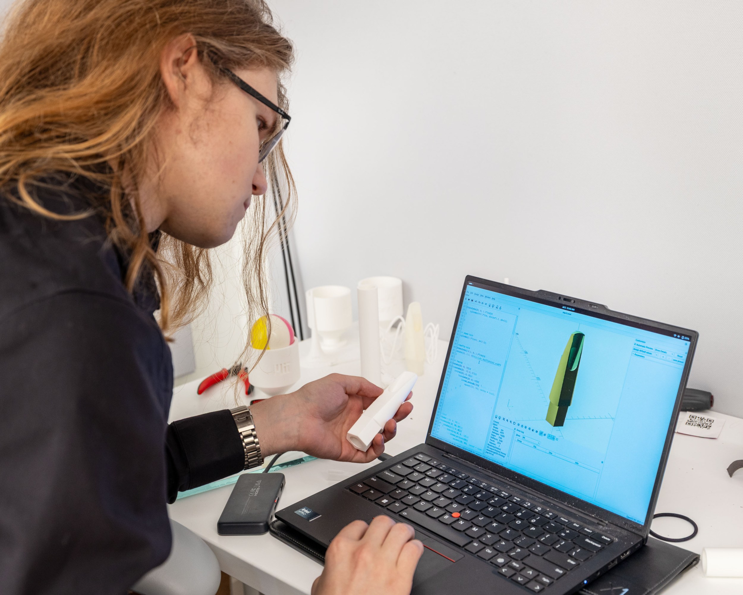 Alex at a laptop with a prototype in one hand