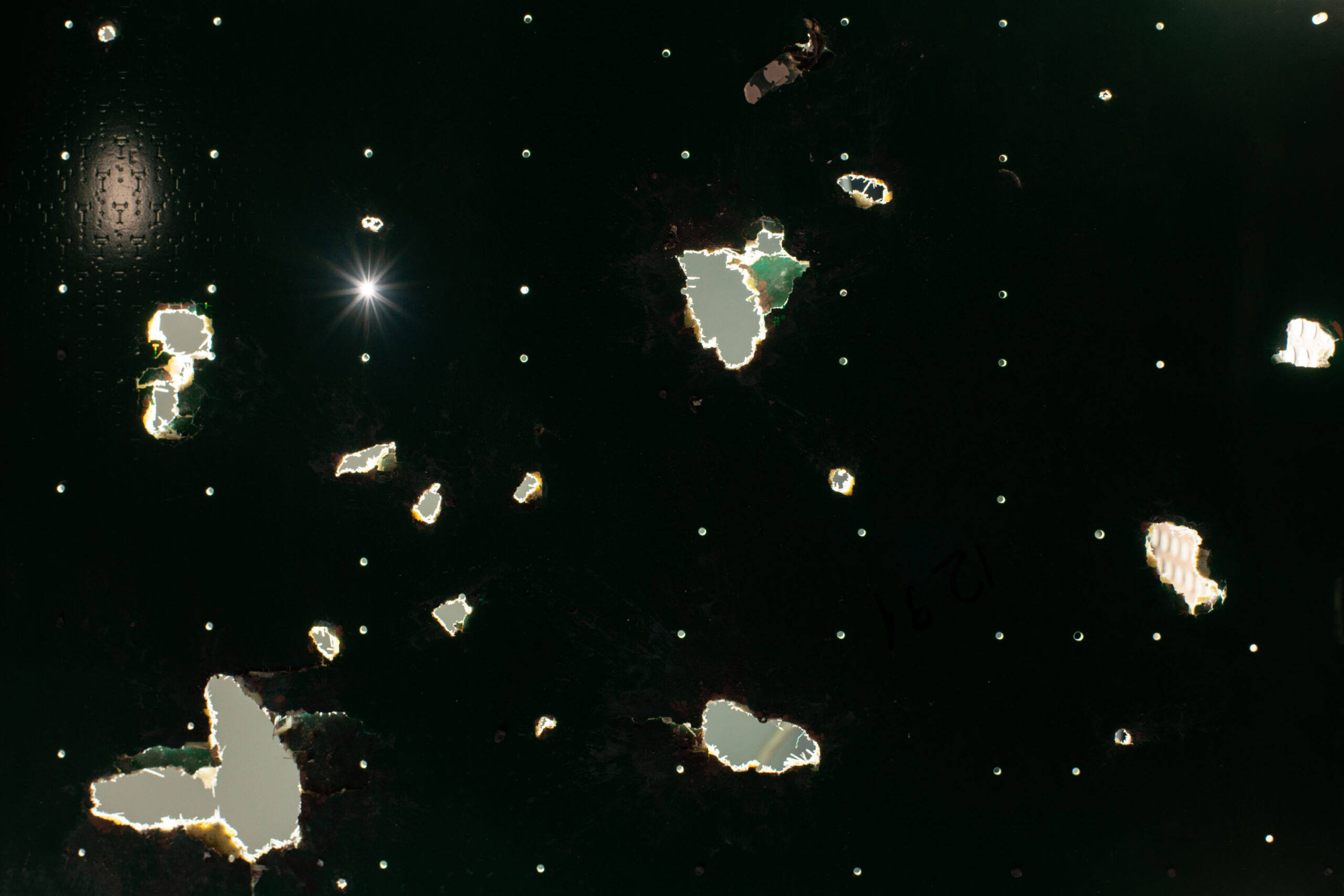 closeup of a Starlink board with light shining through the holes