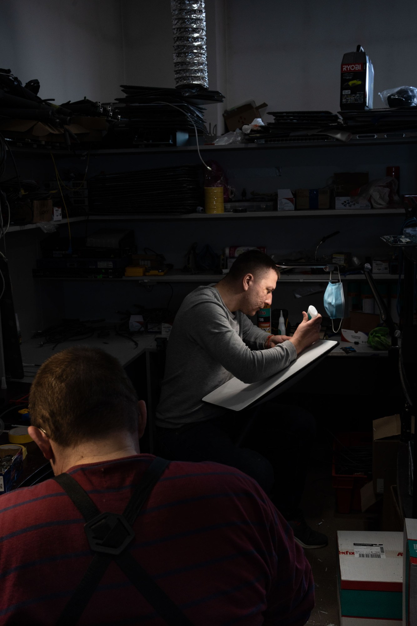 two volunteers at workbenches repairing terminals