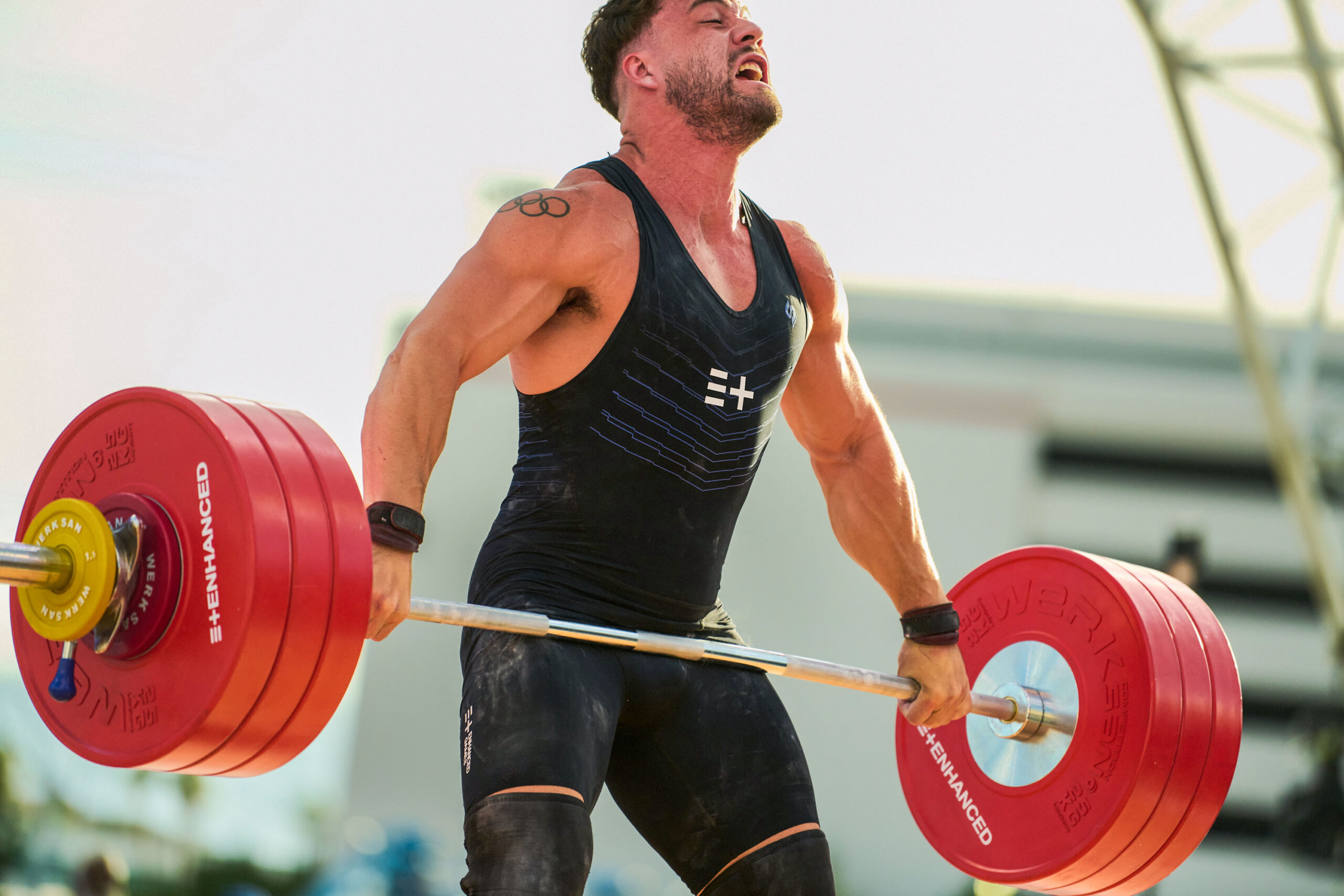 Canadian weightlifter Boady Santavy strains to lift a barbell which is currently level with his hips