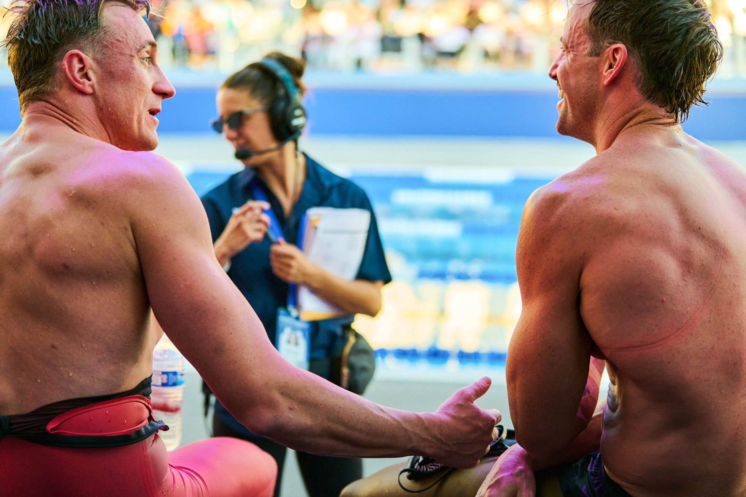 Over the shoulders of Shane Ryan (left) and James Magnussen (right) as they sit and talk poolside