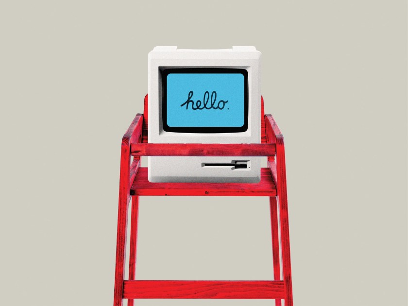 a retro computer with the word hello in script on the screen sits in a child's high chair