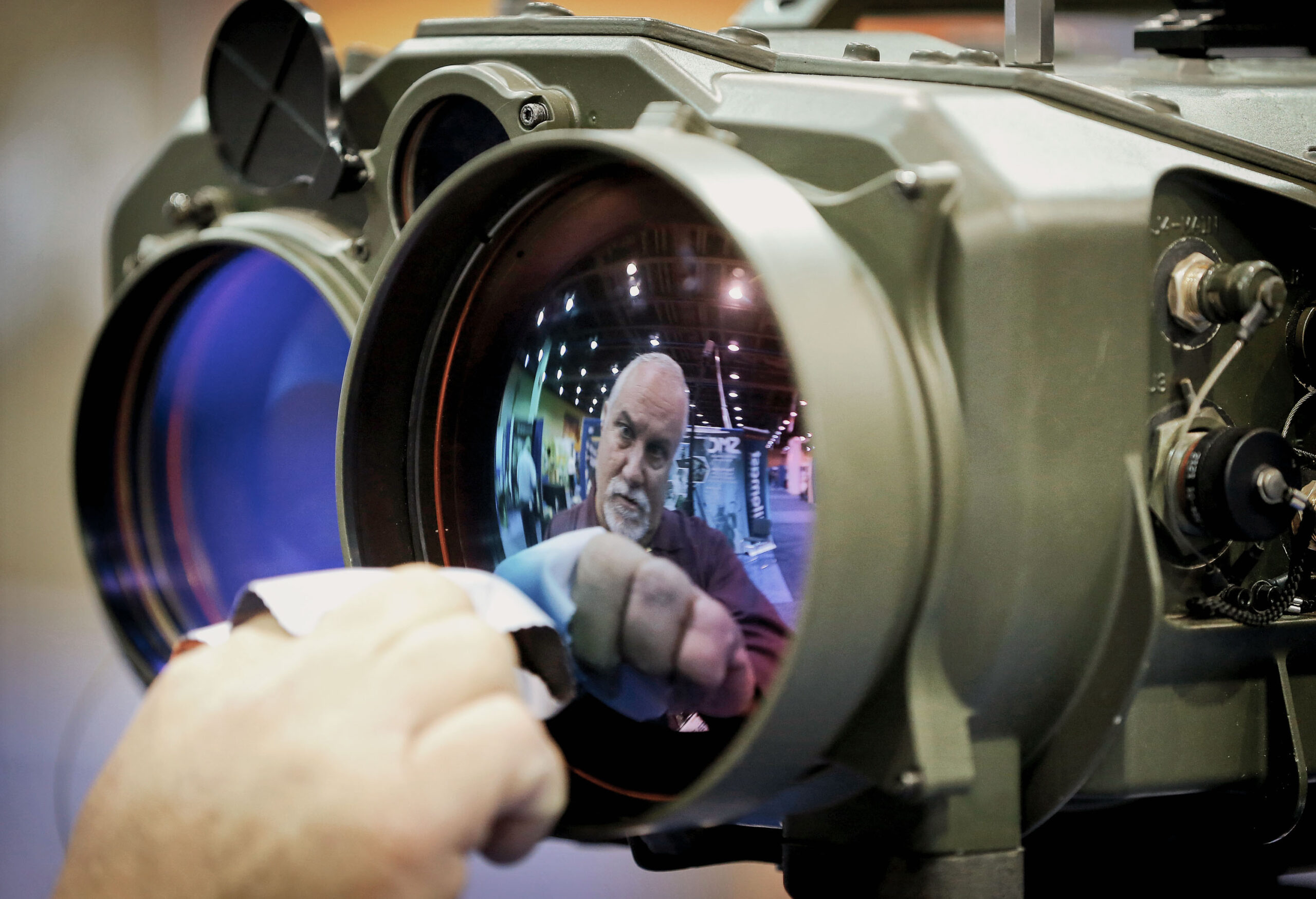 Gary Wagner, of Elbit Systems of America, cleans the lens of a long range thermal imaging targeting system at the 8th annual Border Security Expo, Tuesday, March 18, 2014 in Phoenix.